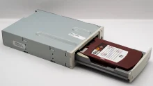 Vintage computer backup tape drive with open tray, showcasing retro technology.