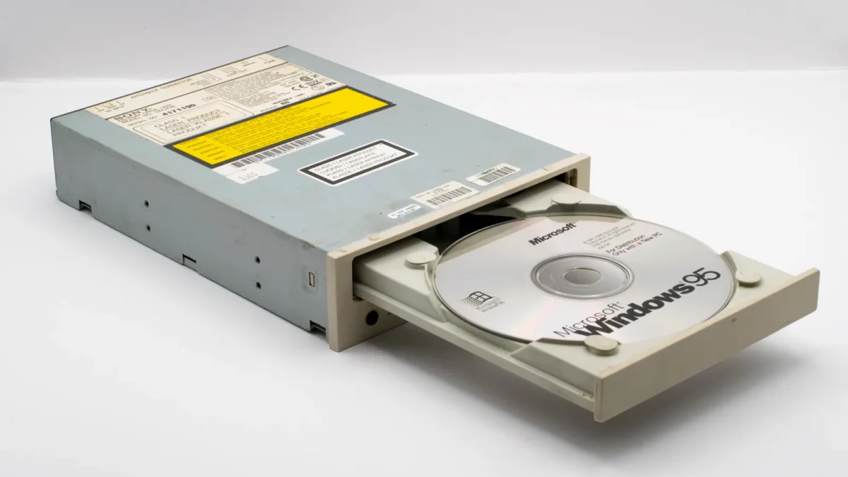 Vintage CD-ROM drive with Microsoft Windows 95 disc, iconic retro tech.