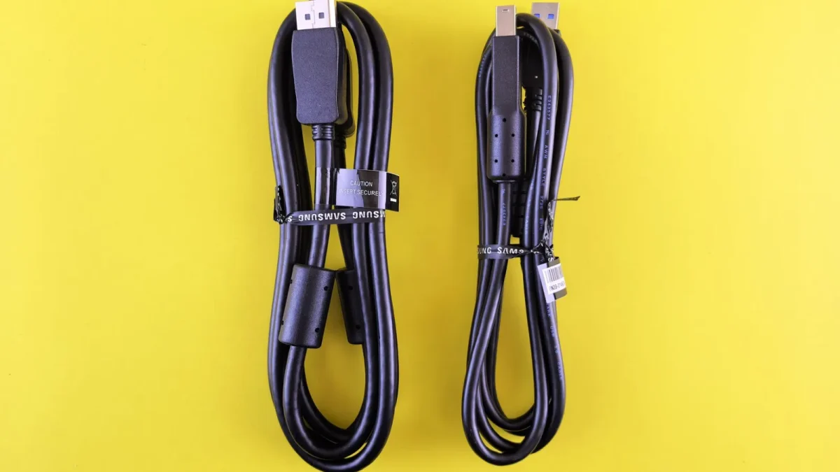 Pair of black Samsung USB cables neatly arranged on a vibrant yellow surface.