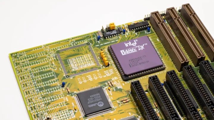 Close-up of a vintage Intel 486 CPU motherboard with PCI slots, highlighting retro technology components.