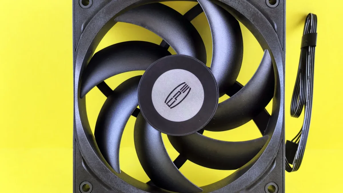 Black computer cooling fan on a vibrant yellow background, highlighting its design.