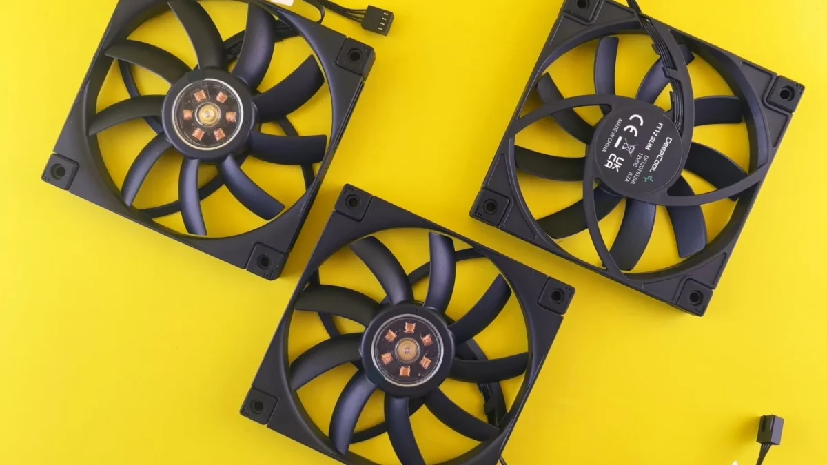 Three black computer cooling fans arranged on a vivid yellow backdrop, perfect for tech themes.
