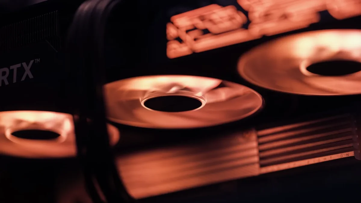 Dynamic close-up shot of illuminated gaming graphics card fans in red light, showcasing cutting-edge technology.