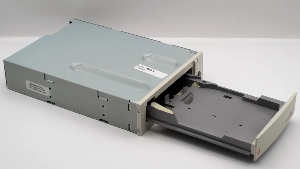 Vintage floppy disk drive with open tray, showcasing retro technology.