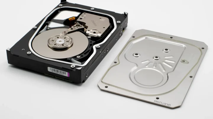 Detailed view of an open hard drive showing the internal discs and cover plate.
