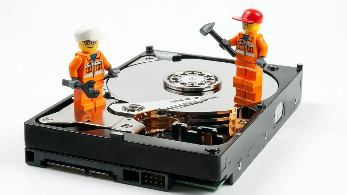 a couple of legos standing next to a hard drive