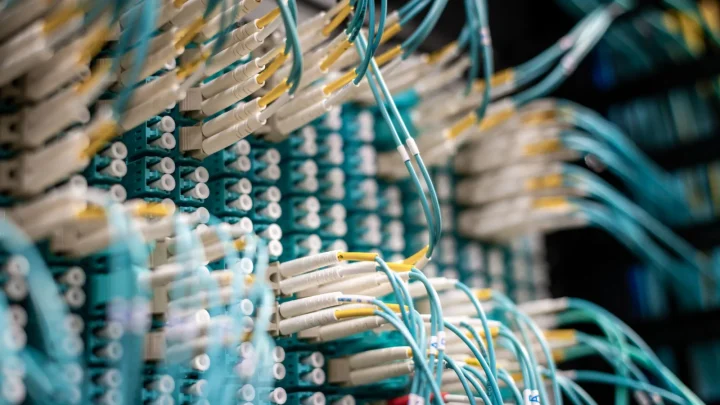 From below of fiber optic switch with sockets and connected rubber cables on blurred background