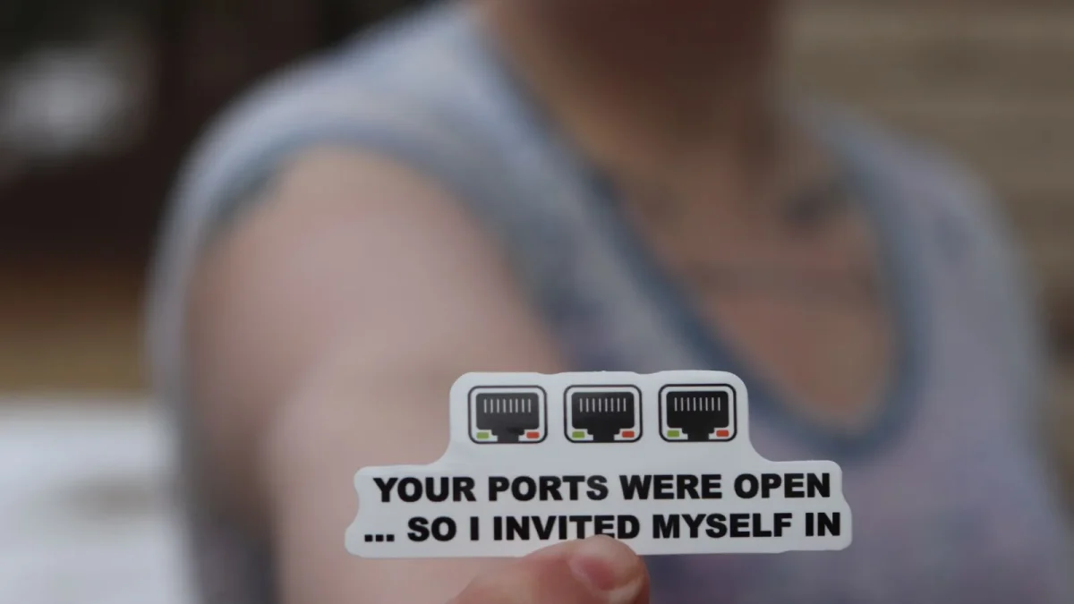 Person holding a funny internet security sticker about open ports.