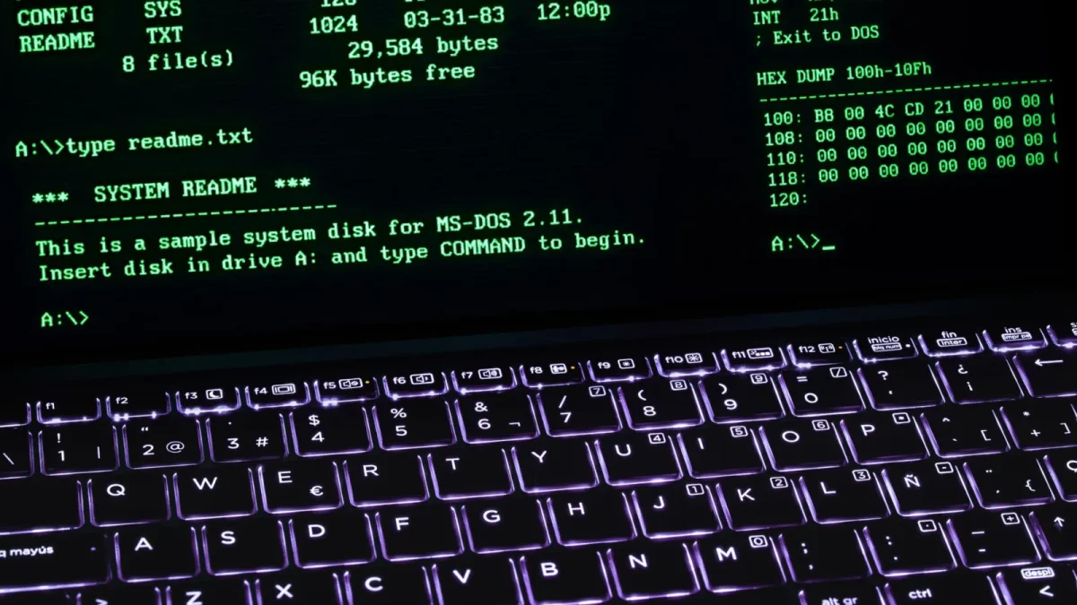 A classic MS-DOS terminal screen displayed on a laptop keyboard with vivid illumination.