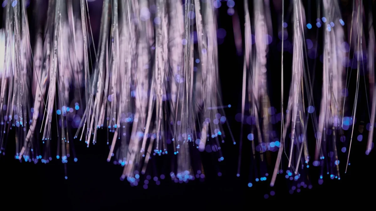 Close-up of glowing fiber optic lights with a purple and blue bokeh effect.