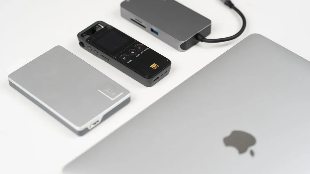 A collection of sleek tech gadgets on a minimalist desk, showcasing modern technology.