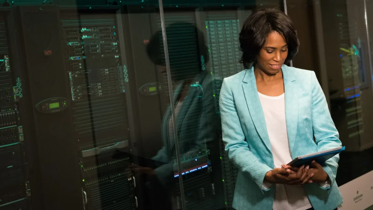 Female IT professional examining data servers in a modern data center setting.