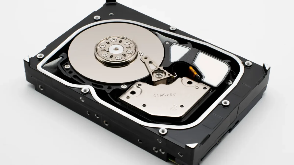 Detailed view of an open hard disk drive with visible platters and actuator arm.